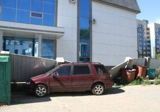 Сильный ветер в Усть-Каменогорске повалил забор на два автомобиля