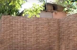 «Живем, как изгои»: аварийный дом в Алматы власти «спрятали» за высоким забором